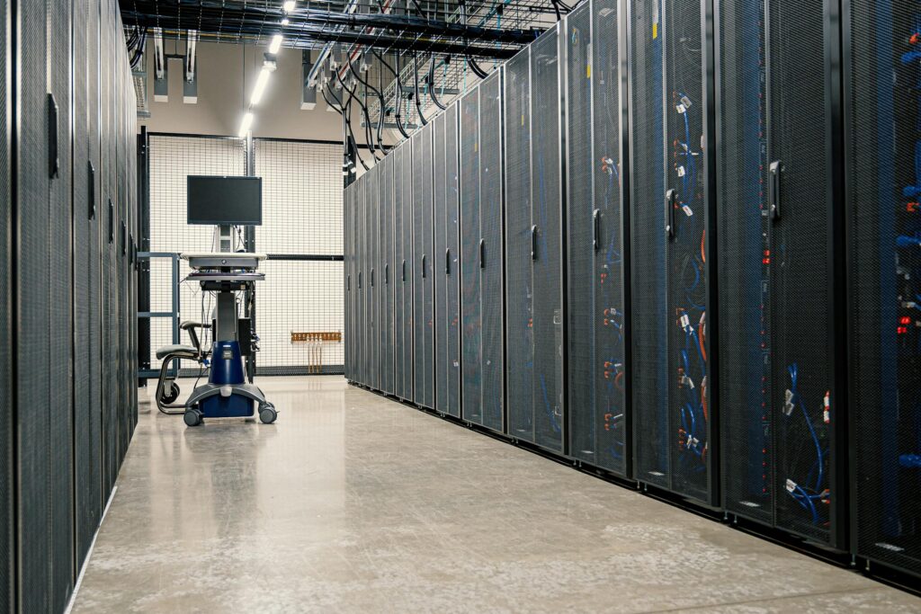 Modern data center corridor with server racks and computer equipment. Ideal for technology and IT concepts. ممر مركز بيانات حديث مزود برفوف خوادم ومعدات حاسوبية. مثالي لمفاهيم التكنولوجيا وتقنية المعلومات.